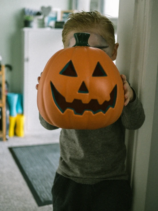 a  holding up a pumpkin shaped bag