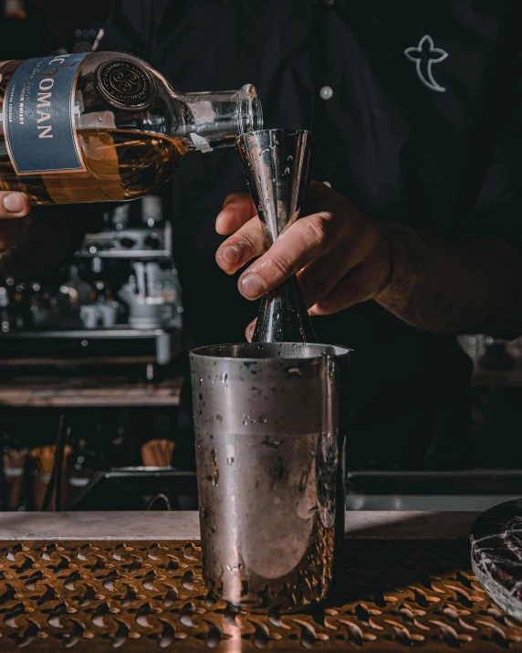 bartender adding ginspool into the glass of his drink