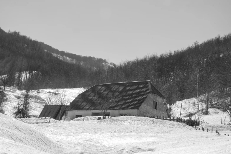 a snow covered hillside with a small building