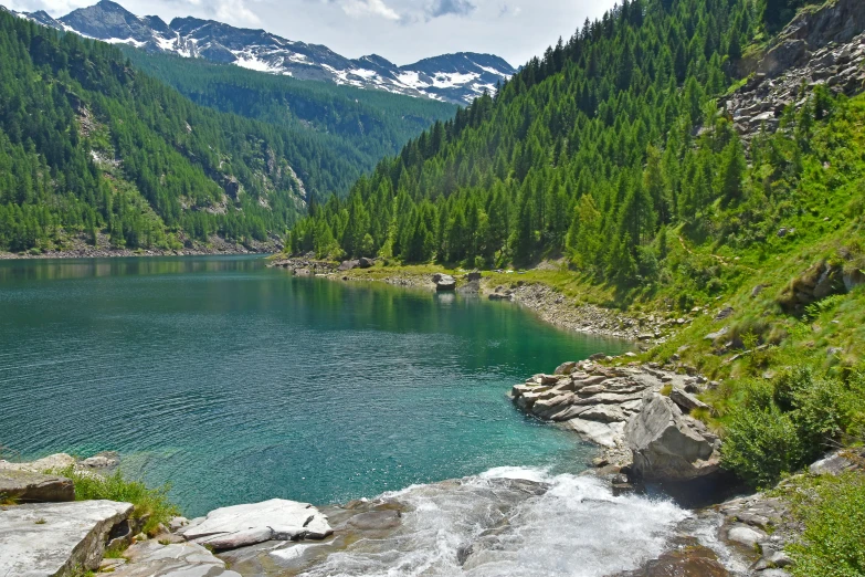 water surrounded by rocks and vegetation in a large lake