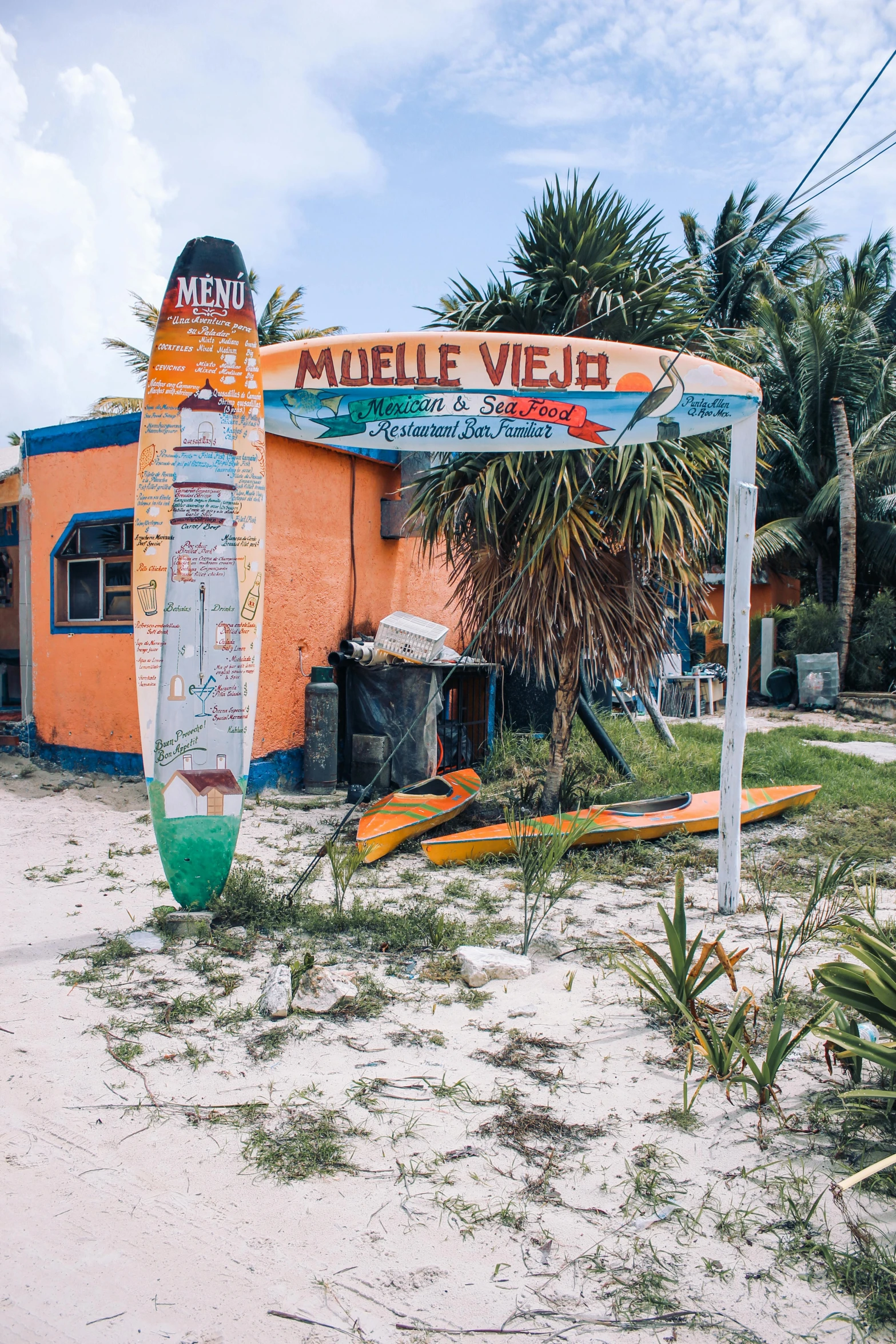 a surf board with boards leaning out of it's way into the sand