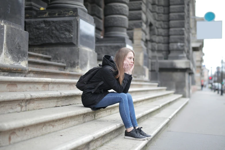 a girl sitting on stairs with her feet crossed