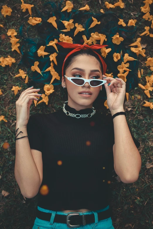 a woman in glasses posing for a po surrounded by flowers