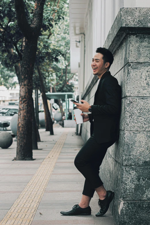 a man leaning up against a concrete wall