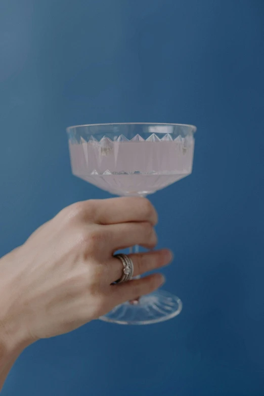 the hand is holding up the small glass