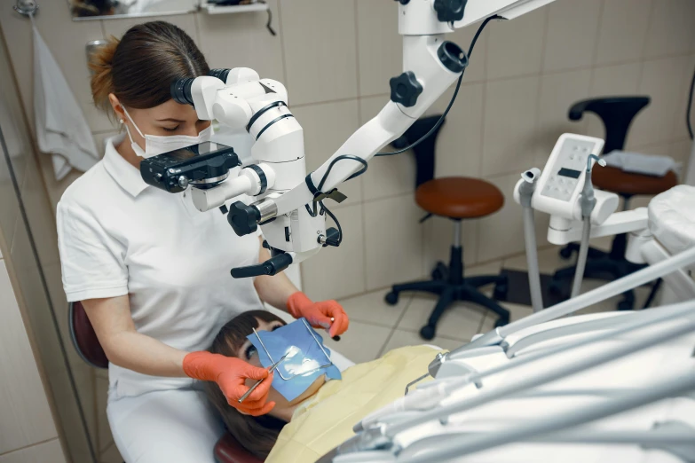 a woman sitting down and a robotic hand holding a small child