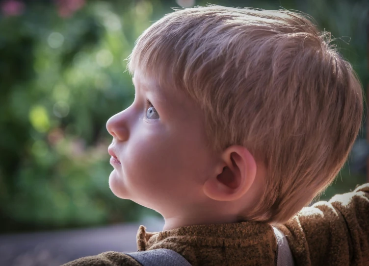 a child with blue eyes staring off into the distance