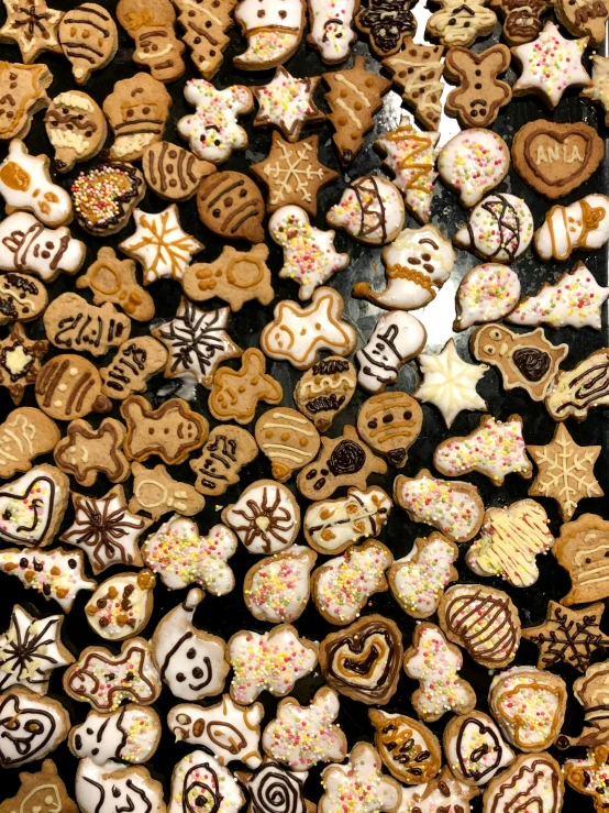 a variety of cookies are on display with frosting