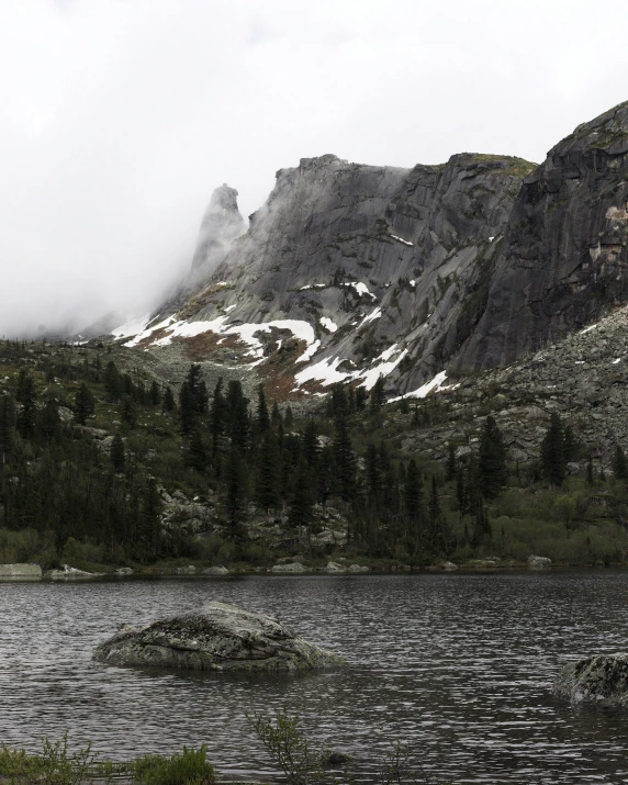 a lone boat on a lake surrounded by mountains