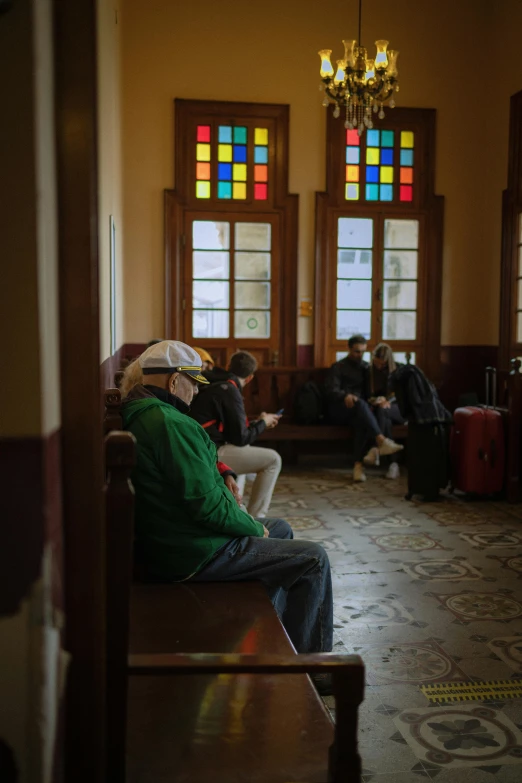 people sitting in a large building with stained glass windows