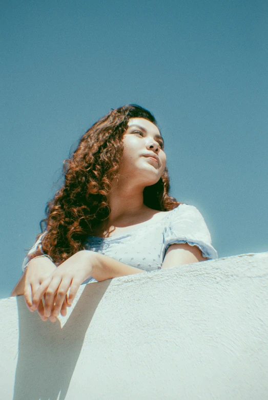 a woman standing on a ledge in the shade