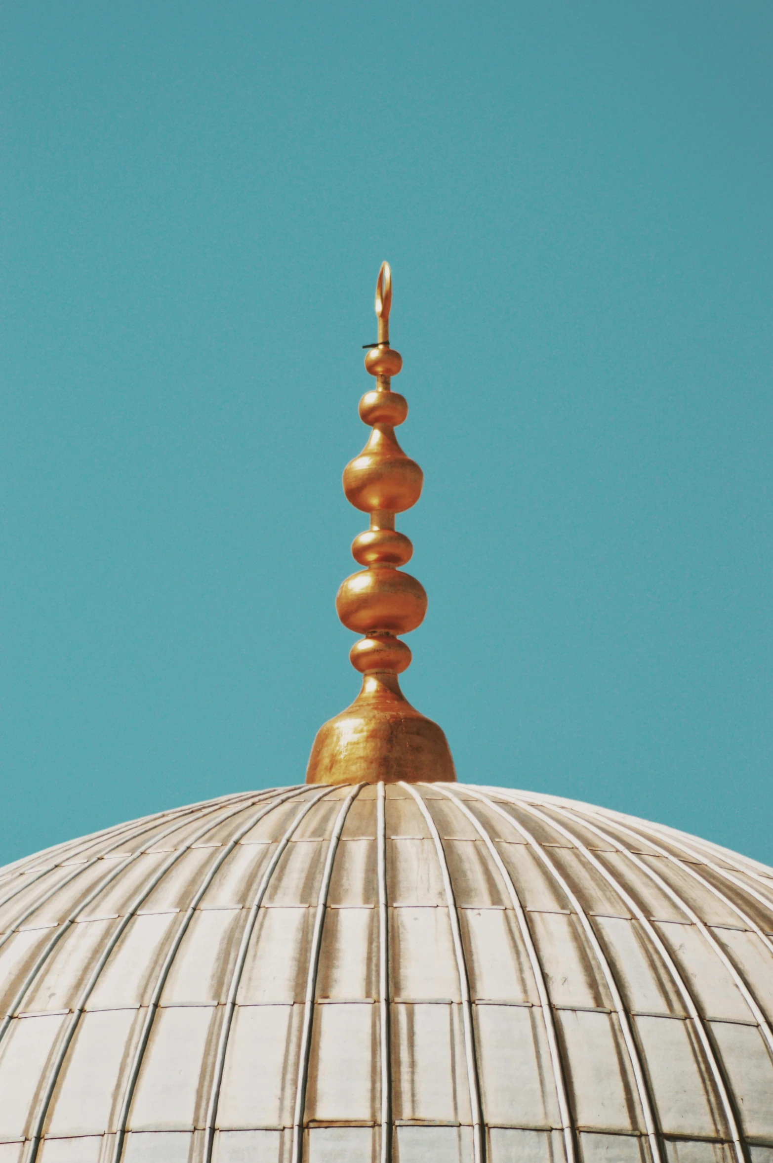 a dome with metal finial and gold spiral design