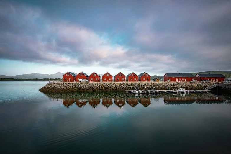 several red buildings in the middle of water with fog