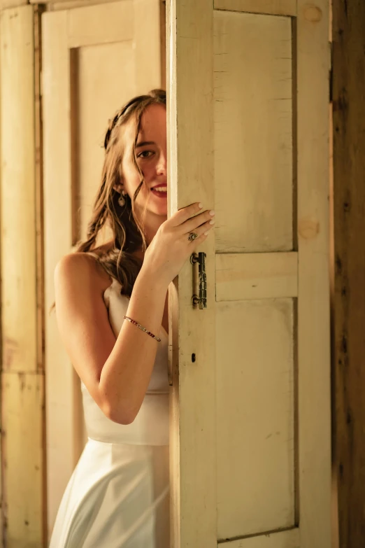 a beautiful woman holding onto an old door