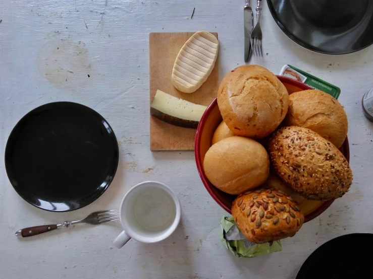 various types of bread sitting in a bowl next to a bowl of ers