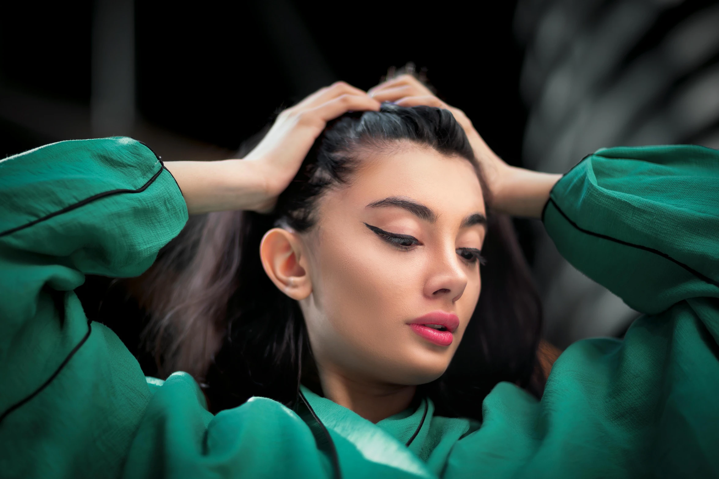 a woman covering her eyes and touching her hair