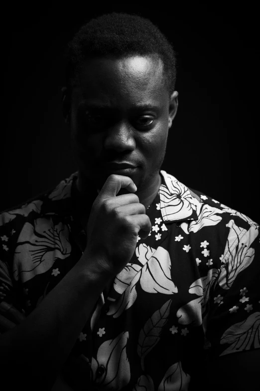 a man in a flower shirt covers his mouth while praying