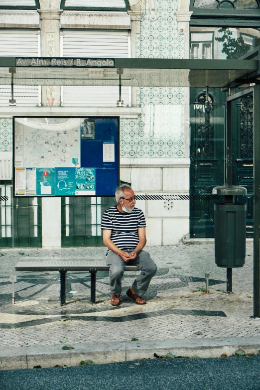 a man sitting on a bench in front of a building