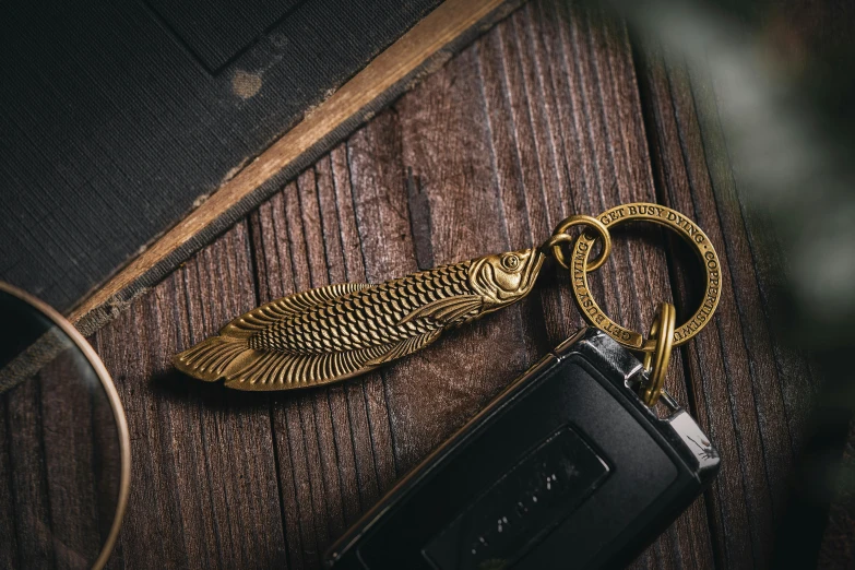 a keychain with an open wing is hanging from a table