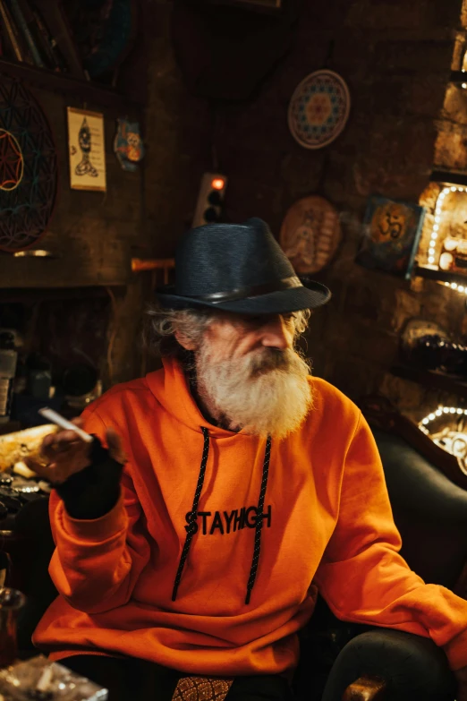 a old man in an orange shirt and hat