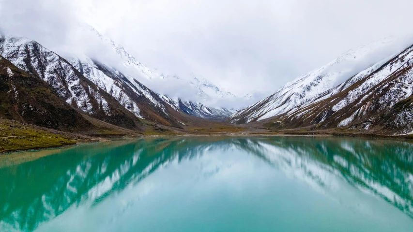 a calm mountain lake surrounded by snow