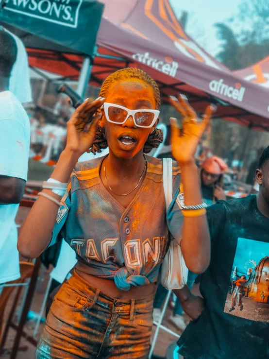 a man and woman are covered in bright yellow orange powder