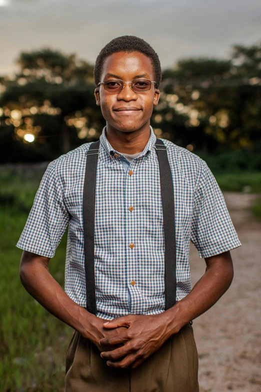 a man wearing brown suspenders and holding his hands in his pockets