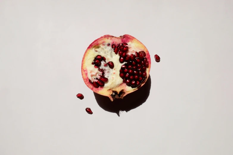 a half cut open pomegranate, showing the contents