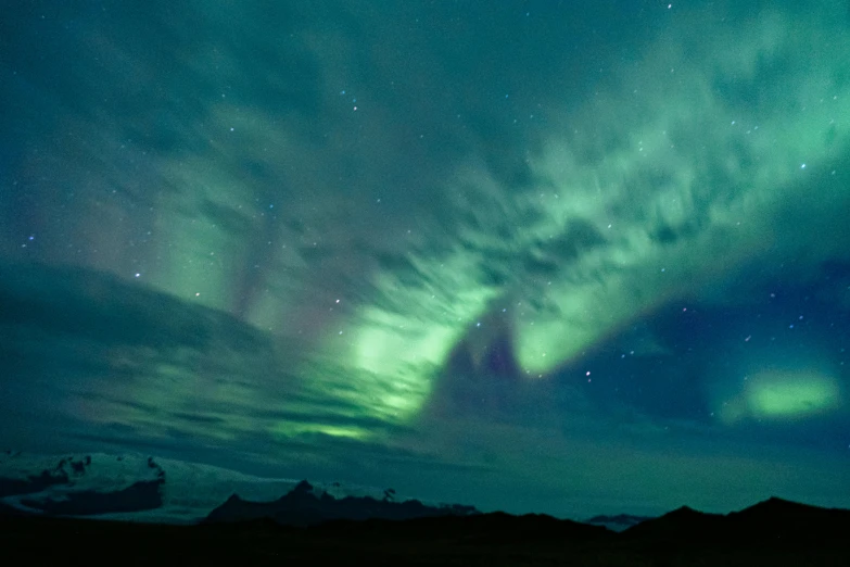 the sky is full of bright green lights as clouds are lit up