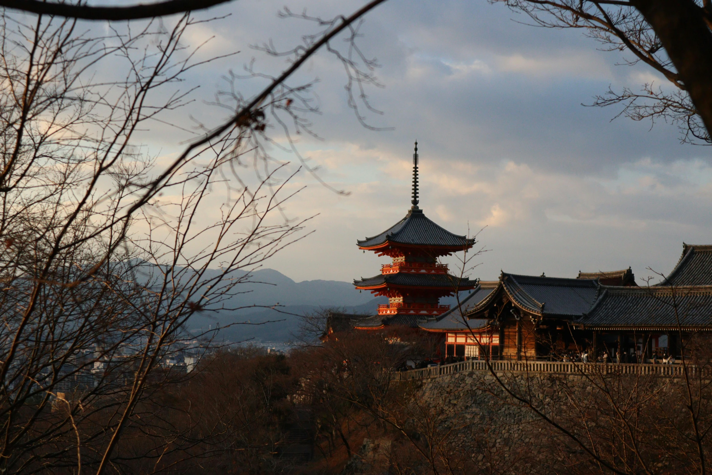 the sky over a temple with mountains in the background