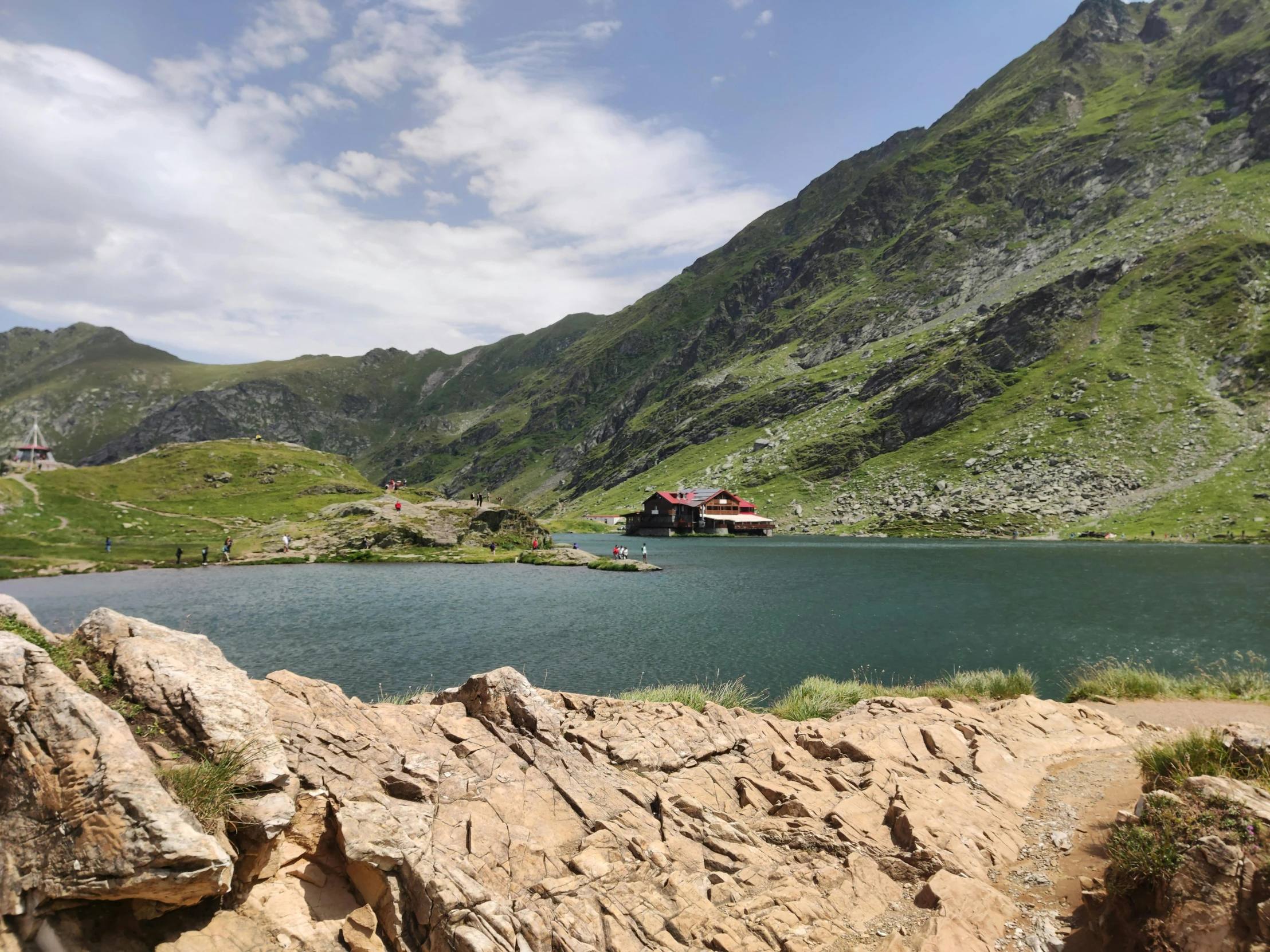 a boat parked near some mountains and green water