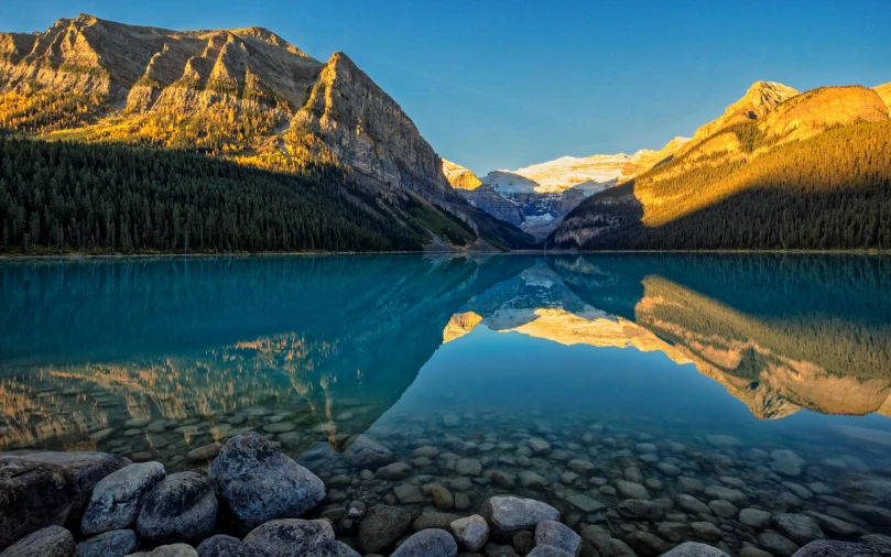 a lake surrounded by mountains near the shore