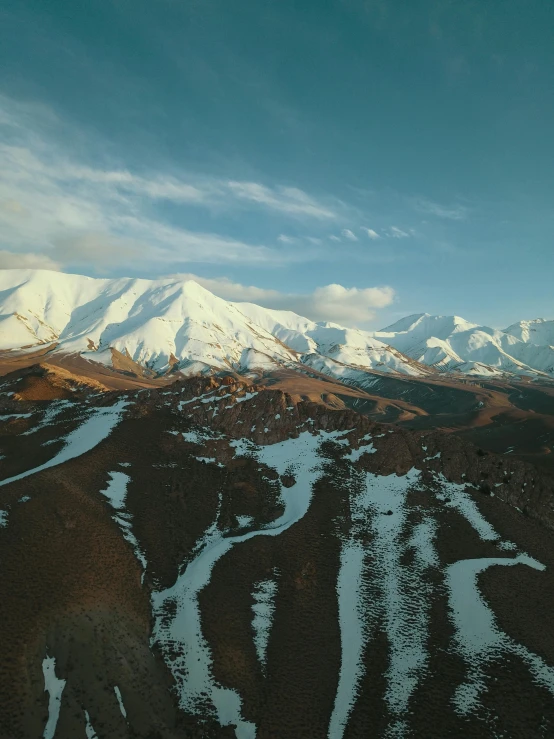 a snow covered mountainside is shown under clouds