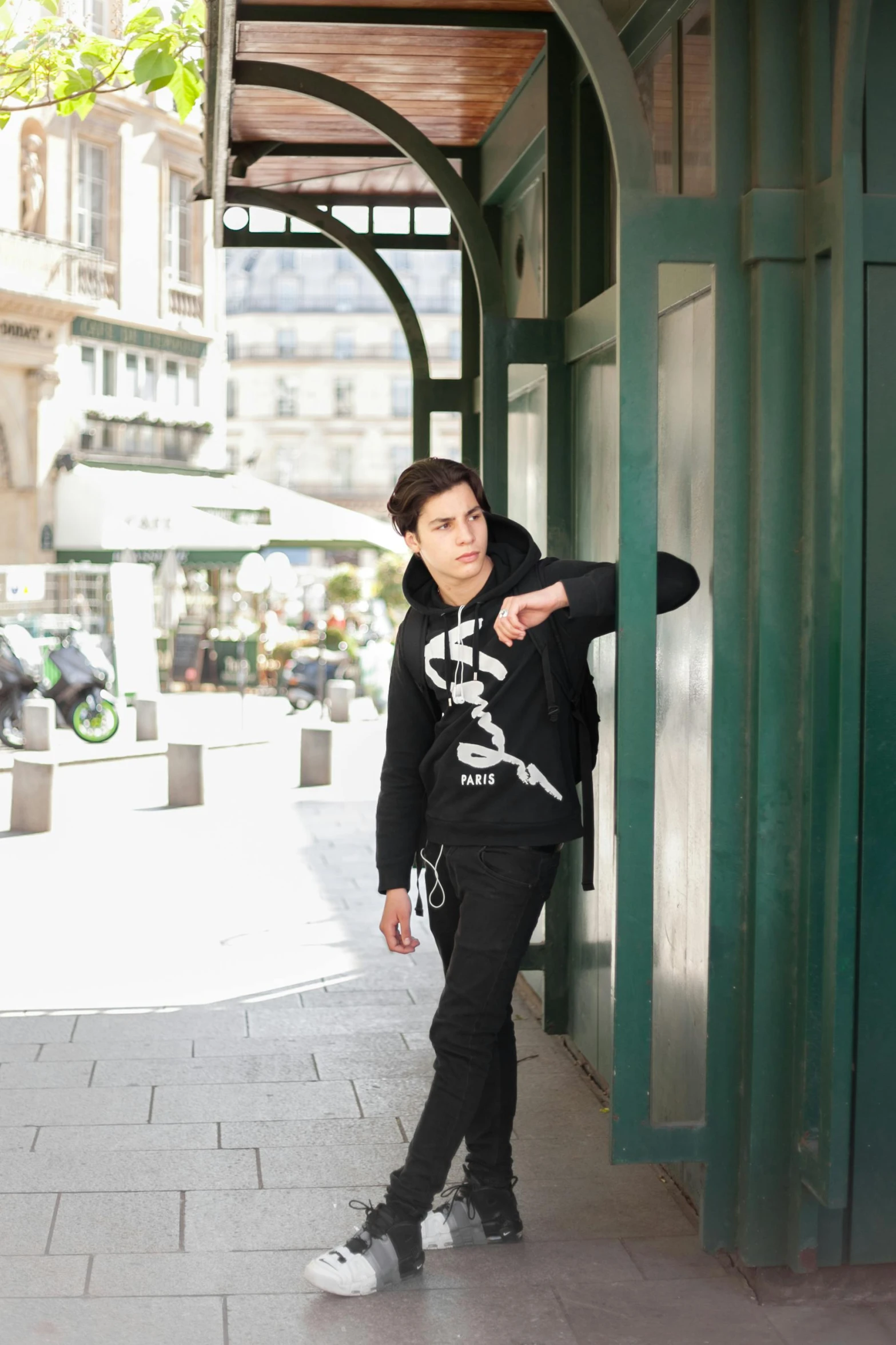 a young man is standing by a building