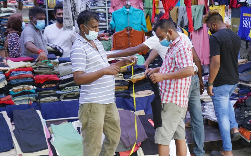 a group of people standing around in front of tents and clothes