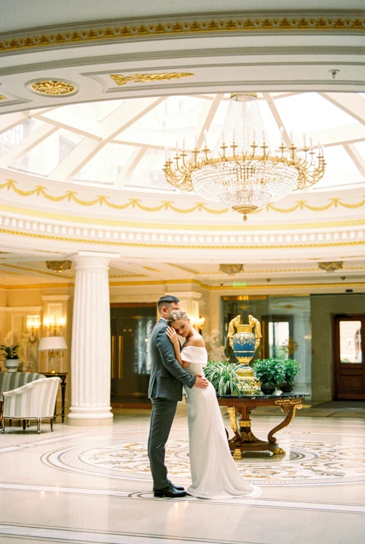 a bride and groom standing in a ballroom