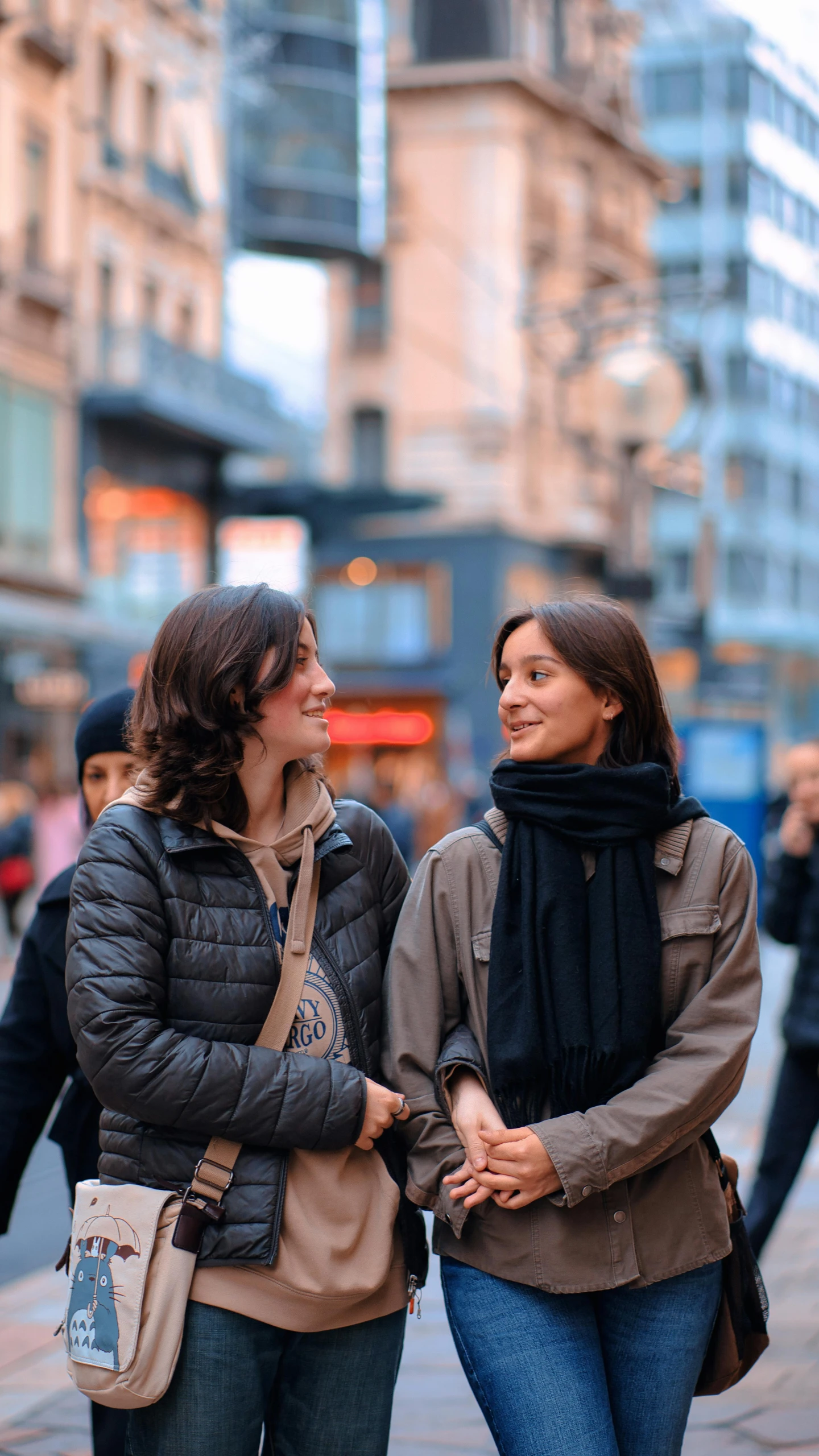 two women laugh as they walk down the street