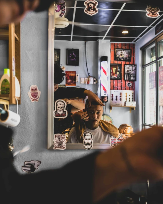 man brushing his hair in front of mirror at barber shop