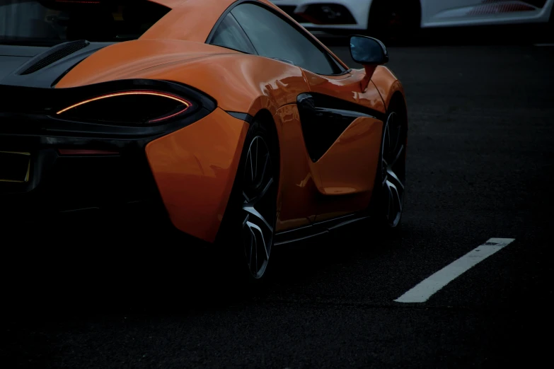 an orange sports car with a black tailpipe