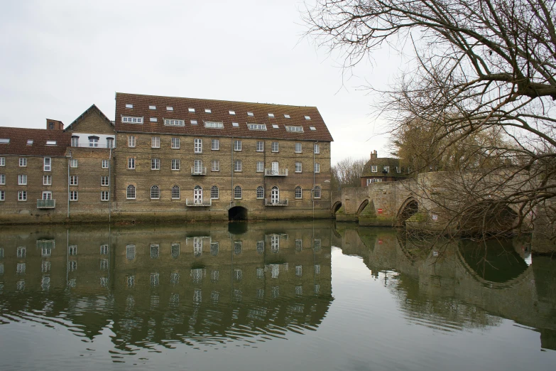 a large brick building is on a lake