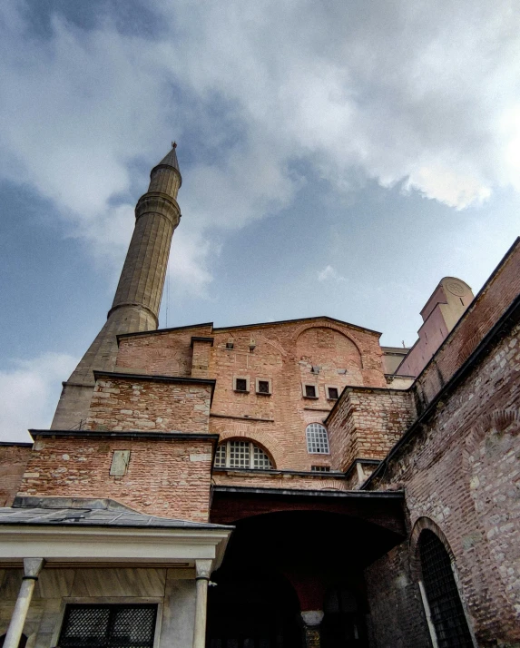 an ornate building with brick walls and a steeple in the background