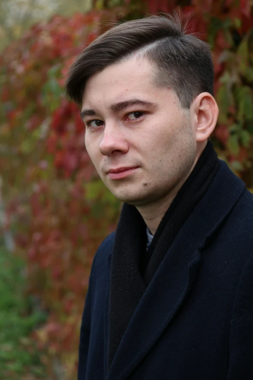 a man looking off to the side wearing a black coat