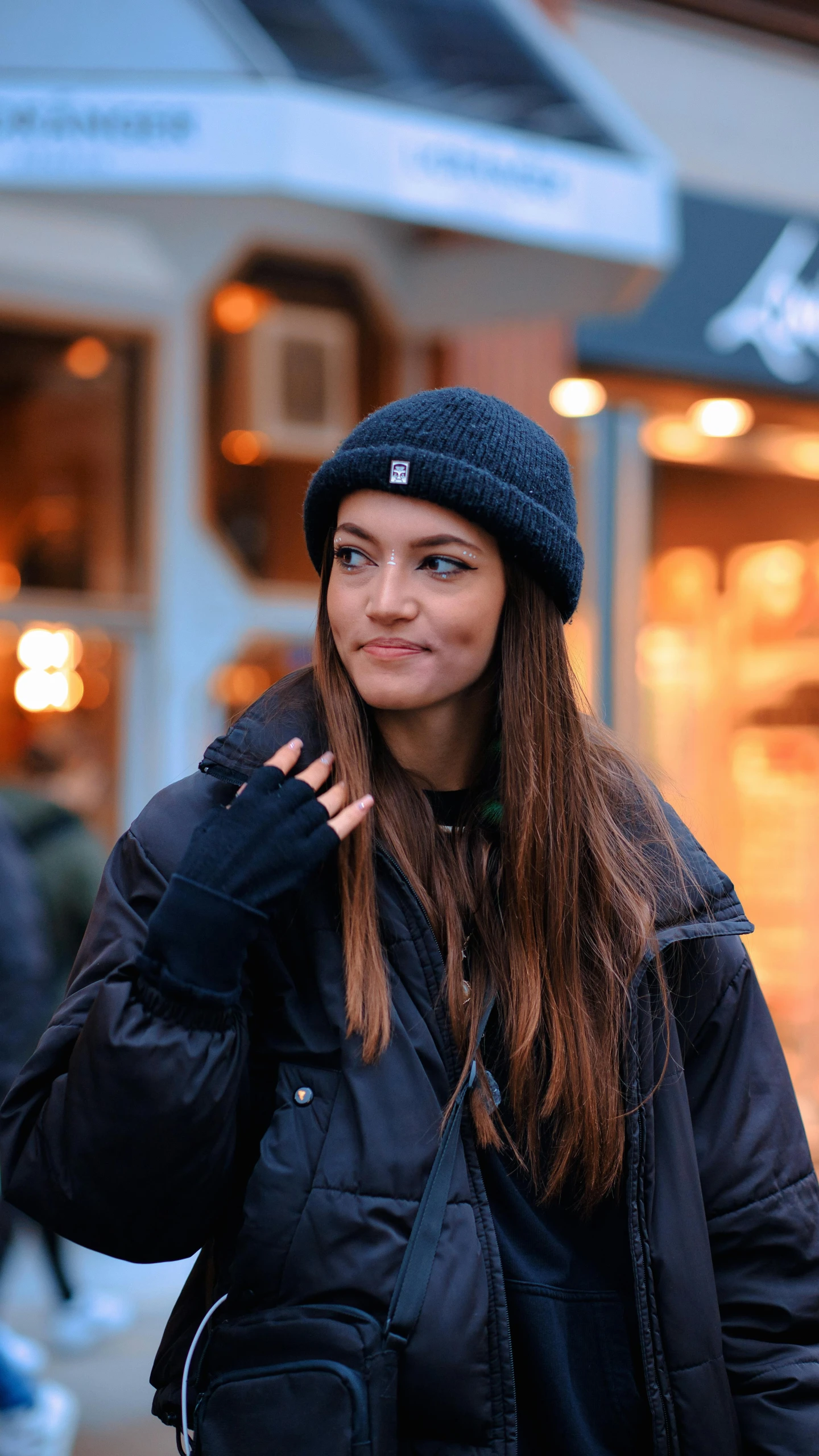 a girl wearing a beanie smiles into the camera