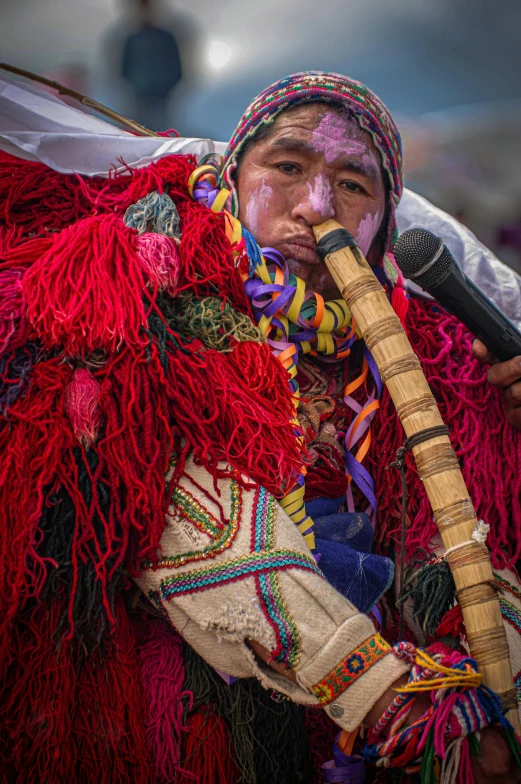 a man with white paint on his face holding a stick