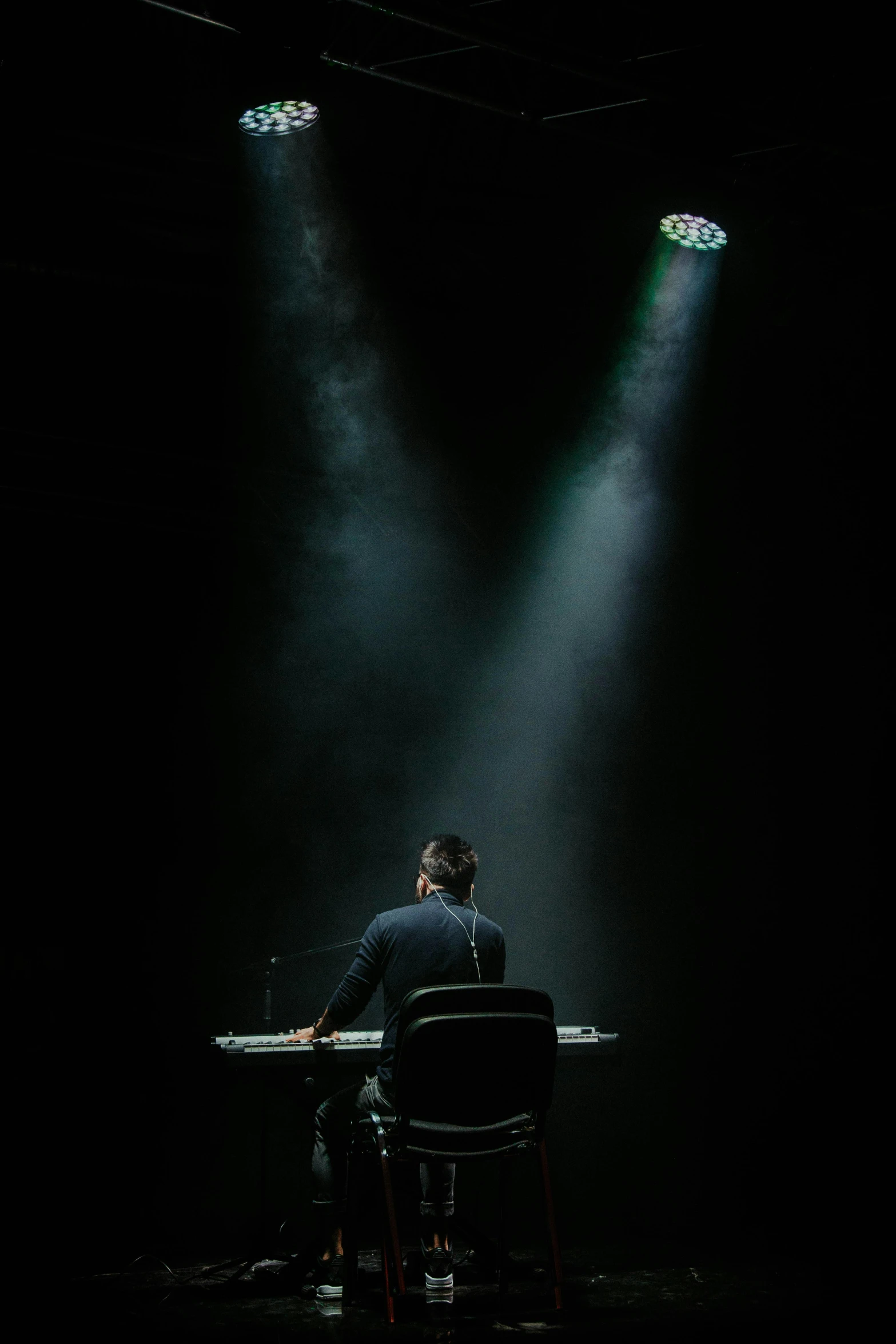 a man is sitting at a desk with three lights on