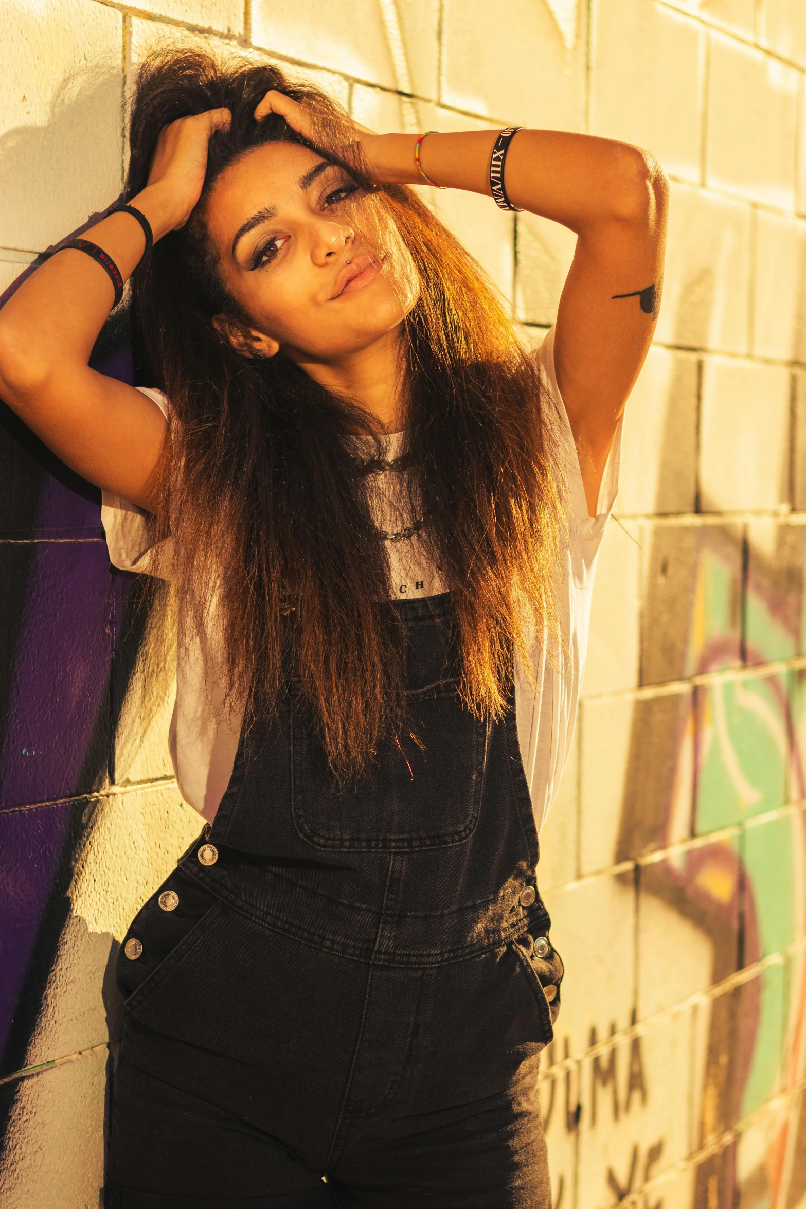 a woman with long hair standing next to a wall