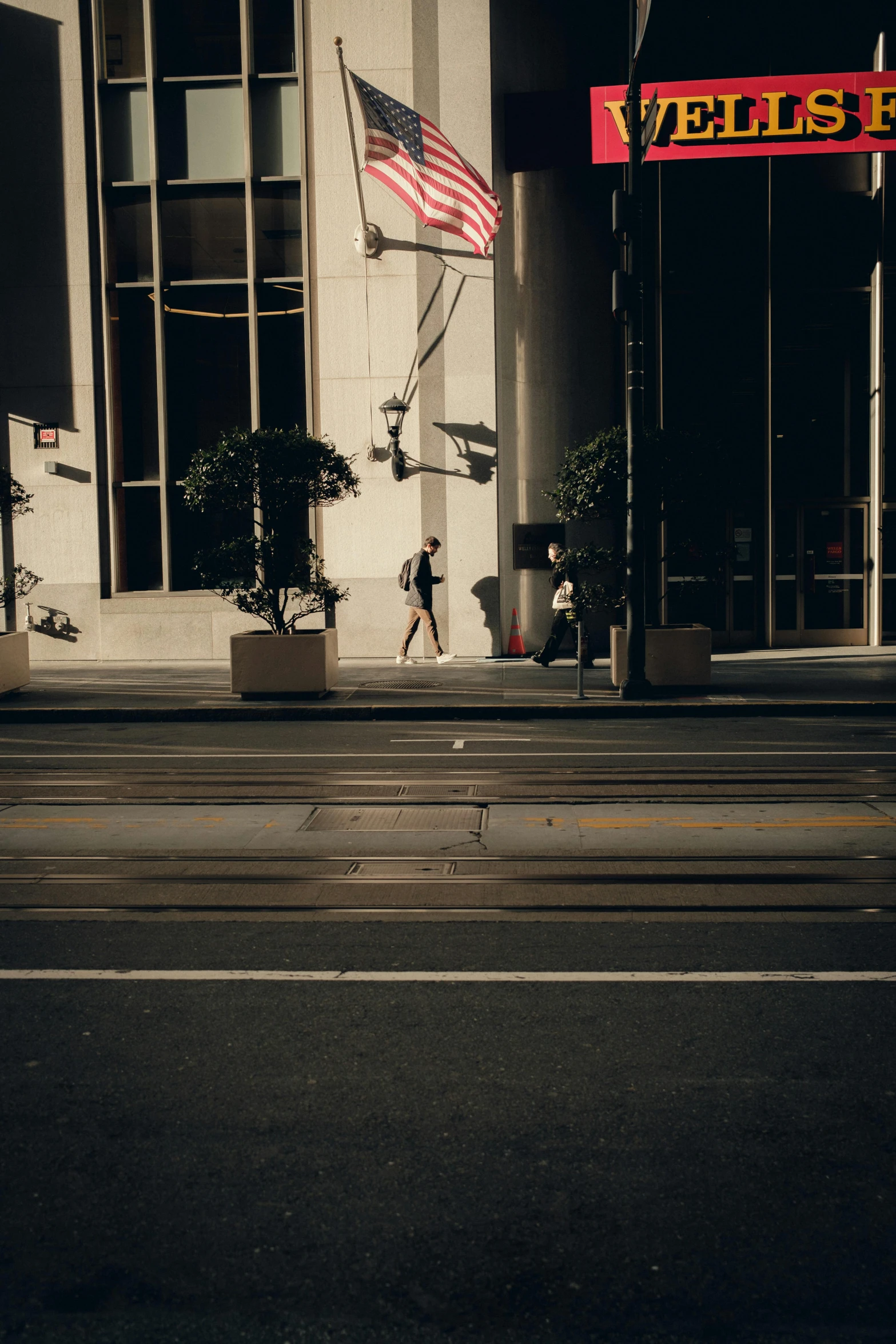 a man that is walking across a street with a flag