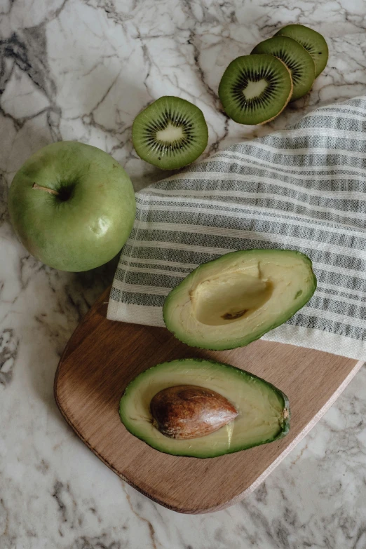 the green apple is sliced on the  board