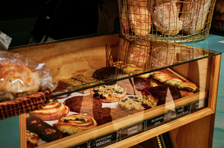 pastries are displayed in glass case with wood border