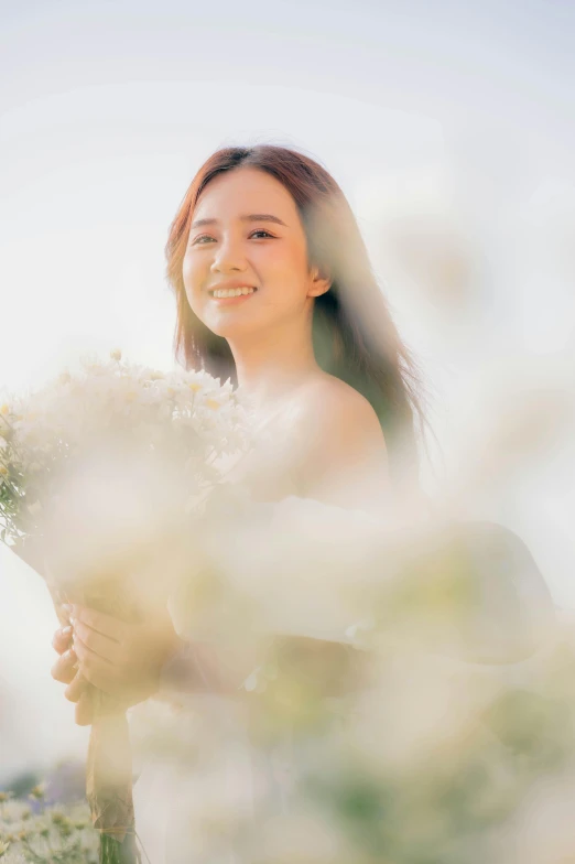 a woman smiles while holding a bunch of flowers